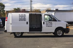 Cargo van with open door and C.C. Rental branding in parking lot